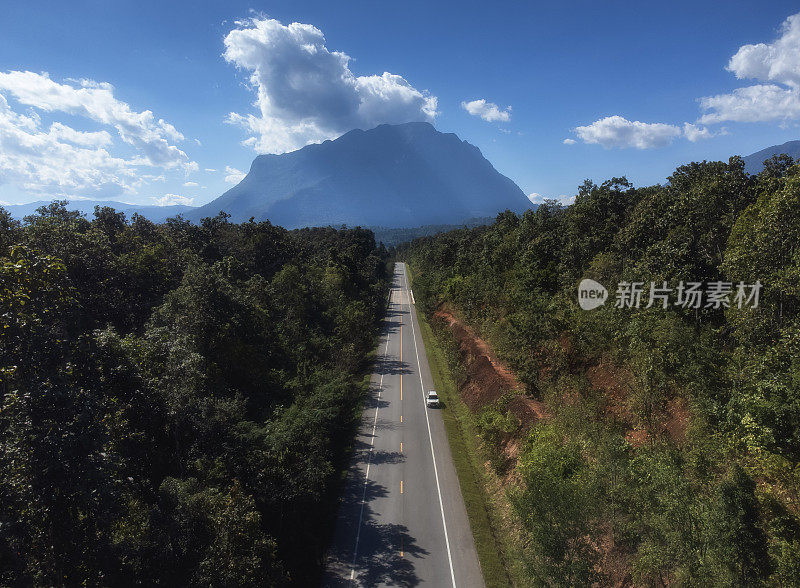 在一个明亮的日子里，在秋天的森林中有笔直的道路的Doi Luang Chiang Dao山的空中景观。